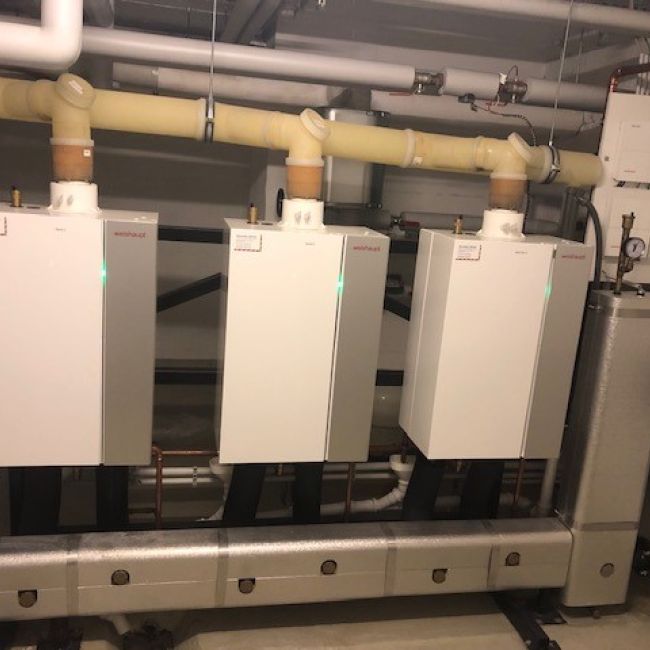 Galerie mit zwei Bildern: Moderne Heiztechnik mit mehreren wandhängenden Brennwertgeräten, Pufferspeichern und umfangreicher Rohrinstallation.